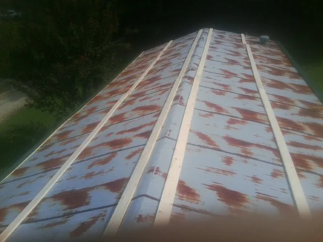 Rusted metal roof panels with new wood purlins before replacement — Storm Damage Roof Repair in Crozet by Roofing Brothers
