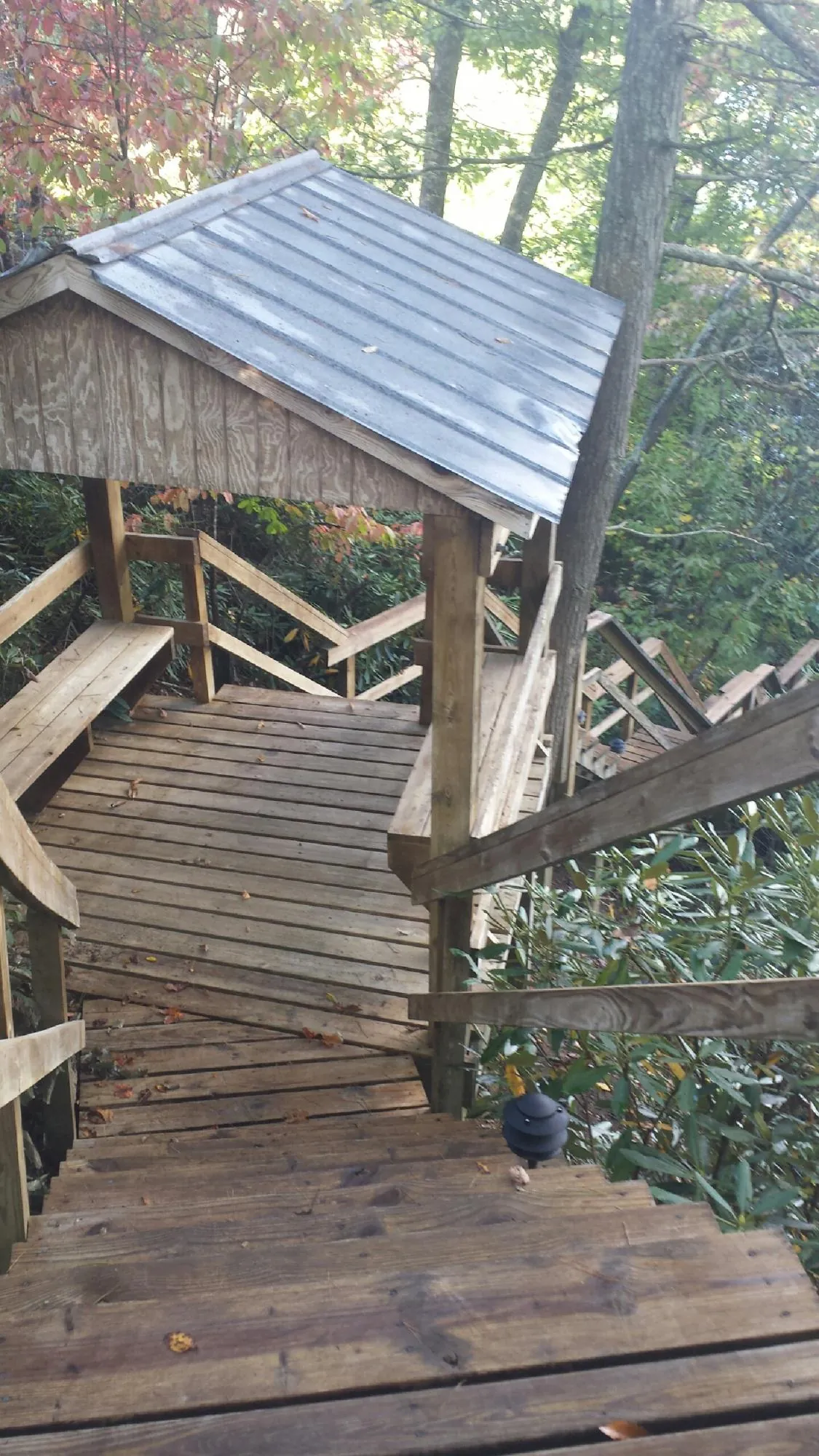 Metal roofed shelter over wooden steps on a wooded walkway — Skylight Repair & Installation work by our crew in Crozet