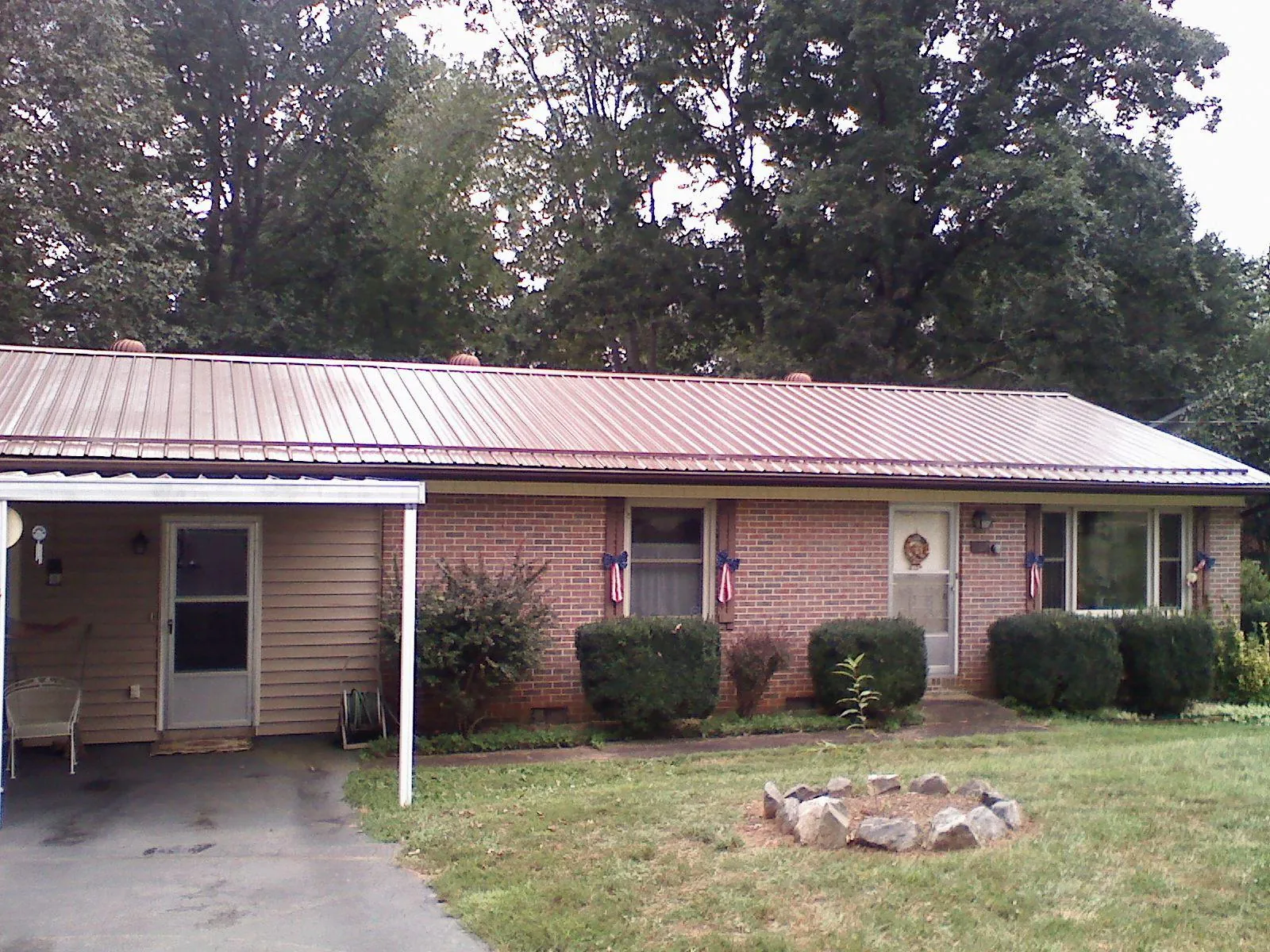 Bronze metal roof and carport on a brick ranch home — Roof Repair work by our crew in Crozet